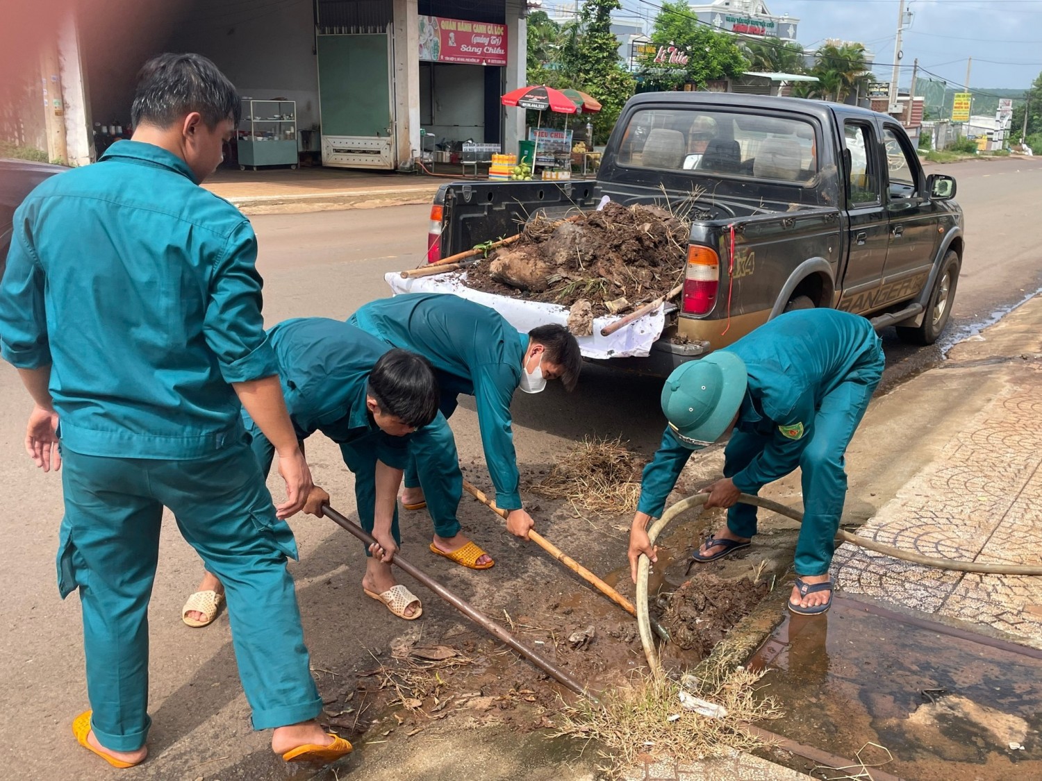 Lực lượng dân quân thường trực xã Bù Nho tiến hành khơi thông các miệng cống thoát nước